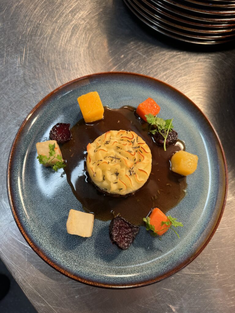 Pulled lamb shoulder shepherd’s pie, root veg served with red wine and rosemary gravy- care catering dish